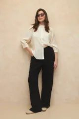 Pantalón de lino color beige, de corte recto y tiro alto, con costuras marcadas en el centro de cada pierna.