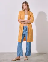 Cardigan largo de punto texturado color mostaza, sin cuello ni cierres, con mangas tres cuartos.