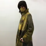 Tapado largo de lana merino afieltrada color gris con toques de amarillo. Diseño abierto al frente, de corte amplio y mangas largas.