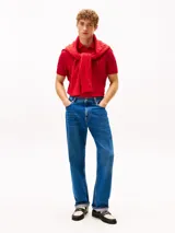 Chomba Tommy Hilfiger de corte regular, color rojo, confeccionada en piqué de mezcla de algodón elástico con tecnología Flex. Cuenta con cuello polo, cierre frontal de dos botones y el logo distintivo de la marca bordado en el pecho.