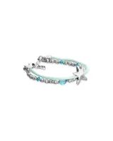 Pulsera de diseño náutico con hilo de seda color turquesa, intercalado con cuentas metálicas plateadas y cristales facetados en tono azul. Presenta un dije central en forma de estrella de mar plateada y cierre de mosquetón con placa de marca.