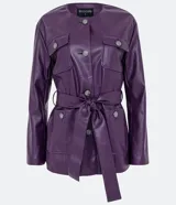 Campera alargada marca Cortelle confeccionada en poliuretano con textura que imita el cuero. Presenta cuello redondo, cierre frontal con botones metálicos, cuatro bolsillos delanteros con solapa y botones, y un lazo ajustable en la cintura.