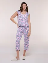 Pijama compuesto por remera sin mangas con escote redondo, botones frontales y detalle de puntilla, acompañado de un pantalón capri con cintura elástica. Presenta un estampado floral en tonos rosados sobre base gris.
