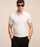 Polo de hombre slim fit color beige, confeccionada en tejido de media malla acanalada de algodón sostenible, con cuello clásico con botones y mangas cortas.