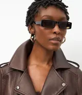 Campera estilo biker de cuero sintético color marrón chocolate, con cuello solapa, cierre asimétrico, bolsillos laterales con cremallera y detalles de botones metálicos. Incluye hombreras decorativas y puños estructurados.