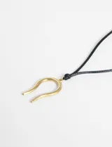 Collar con cordón negro ajustable y dije dorado en forma de herradura.