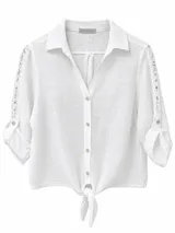 Camisa blanca de lino con cuello camisero, manga tres cuartos con detalles de encaje broderie en los laterales y nudo ajustable en la parte frontal.