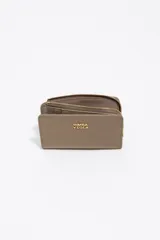 Billetera compacta de estructura blanda en color turquesa, con cierre de cremallera superior y logo metálico dorado en el frente.