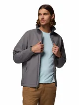 Chaqueta Columbia modelo Ascender Soft Shell, color gris, con cierre frontal completo, cuello alto con protector de barbilla, bolsillo en el pecho con cierre y bolsillos laterales. Cuenta con puños ajustables y tecnología resistente al agua y al viento.