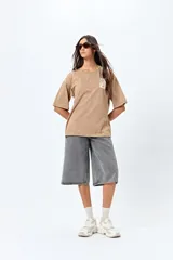 Remera negra de corte amplio con mangas cortas y cuello redondo. Presenta un pequeño estampado rectangular en el pecho y un estampado grande en la espalda con motivos japoneses.