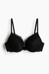 Soutien push-up de encaje negro con aros y copas acolchadas. Cuenta con breteles ajustables y detalles de bordes ondulados.