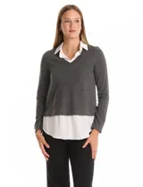 Buzo combinado marca Rio & Rian, con diseño de efecto capas que simula una camisa blanca debajo. Presenta un cuerpo de tejido de hilado fino en color beige con escote en V, y cuello y ruedo de gasa blanca.