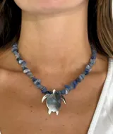 Collar corto con cuentas de piedra azul y dije de tortuga plateada.
