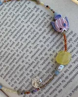 Collar corto de cuentas de colores con dije de pez de cerámica, piedras naturales y detalles en plata 925.