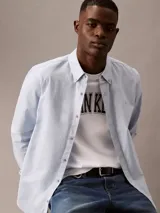 Camisa celeste de algodón Oxford con cuello abotonado, manga larga y logo bordado en el pecho.
