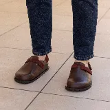 Zuecos de cuero marrón con tira de ajuste de velcro color borgoña.