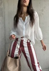 Camisa blanca de tejido liviano y fresco, con calce suelto, cuello de inspiración romántica y mangas amplias con frunces.