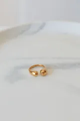 Anillo abierto de acero quirúrgico con diseño de superficie irregular y acabado brillante.