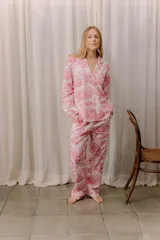 Pijama de algodón con estampado toile de jouy en color rosado, compuesto por una camisa de manga larga con cuello solapa y botones frontales, y un pantalón de corte recto con cintura elástica.