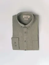 Camisa celeste de lino, de manga larga, con cuello abotonado y bolsillo en el pecho.
