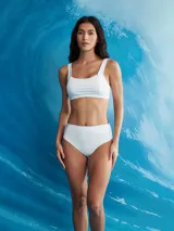 Conjunto de bikini blanco de textura acanalada, compuesto por un top deportivo de escote redondo y tirantes anchos, y una bombacha de tiro alto con cobertura clásica.