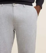 Pantalón de lino blanco de corte recto, con trabillas en la cintura, cierre tradicional y bolsillos laterales.