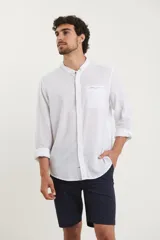 Camisa de cuello mao y manga larga, confeccionada en una mezcla de lino y algodón. Presenta un diseño de corte recto con botones en tono natural y un bolsillo pequeño en el pecho.