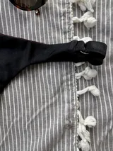 Bottom de bikini colaless negro, sin costuras, con textura de rayitas en la parte delantera y lycra con brillitos en la parte trasera. Breteles regulables en los costados.