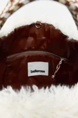 Bolso estilo tote con cuerpo de piel sintética afelpada en color blanco en la parte superior y marrón claro en la base, con asas de mano de cinta marrón.