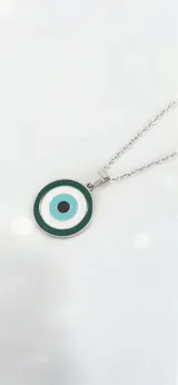 Collar de acero quirúrgico con dije circular de ojo turco esmaltado en tonos verde oscuro, blanco y turquesa.