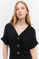 Remera marrón de tejido liso, con escote en V, mangas cortas y cierre frontal con botones.