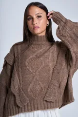 Sweater blanco de punto con cuello alto, diseño de ochos y volados en los hombros.