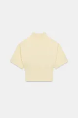 Jersey de punto color amarillo claro, con cuello subido, manga corta con hombreras y cintura entallada.
