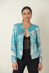 Campera de cuero sintético estampada con diseño abstracto en tonos celeste, rosa y gris. Cierre frontal y bolsillos laterales con cremalleras doradas.