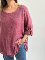 Sweater Ginebra de punto color magenta, con escote redondo, mangas largas con presilla y botón para ajustar, y diseño holgado con bajo asimétrico.