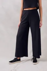 Pantalón negro de corte ancho, tiro alto y textura suave.