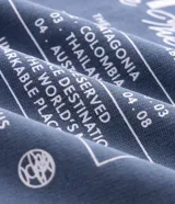 Remera oversized de algodón azul con efecto gastado, cuello redondo y mangas cortas. Presenta un pequeño estampado frontal con inscripciones y gráficos minimalistas.