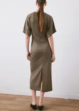 Vestido midi de corte recto y color marrón, con cuello redondo, manga corta y detalles fruncidos.