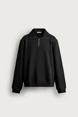 Sudadera regular fit de color negro con cuello subido, cierre frontal de cremallera corta, manga larga y acabados en rib.