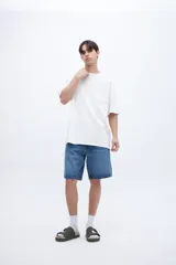 Remera color crudo de algodón con calce oversize, manga corta, cuello redondo y estampa en la espalda con texto en color negro.