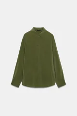 Camisa de manga larga color celeste claro, con cuello solapa y cierre frontal de botones.