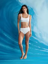 Conjunto de bikini blanco de textura acanalada, compuesto por un top deportivo de escote redondo y tirantes anchos, y una bombacha de tiro alto con cobertura clásica.