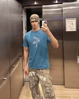 Remera de cuello redondo y manga corta en color azul, con estampado central de carteles de señalización urbana con la inscripción 'KABOA IND' y 'BROTHERHOOD'.