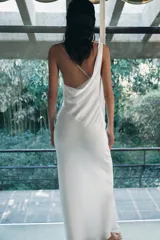 Vestido largo de tejido satinado con escote asimétrico, tirante ancho y tirante fino cruzado en la espalda. Presenta un diseño fluido con forro interior a tono.