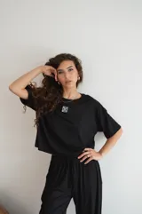 Pantalon de corte recto y holgado, confeccionado en tejido de mezcla de algodón y poliéster, con cintura elástica y cordón ajustable.