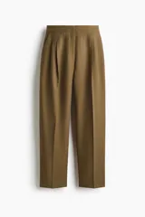 Pantalón de tiro alto de sarga color verde militar, con corte holgado y diseño barrel. Presenta pinzas y pliegues en la parte delantera y trasera, bolsillos al bies y bolsillos traseros decorativos.