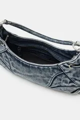 Bolso de hombro de denim con efecto acid wash, pespuntes decorativos, asa corta y tiras laterales con detalles metálicos.