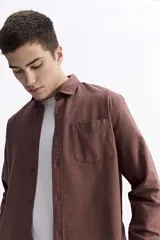 Camisa de manga larga color azul marino con textura, cuenta con cuello clásico, cierre frontal con botones y un bolsillo en el pecho.