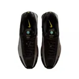Championes Nike Shox R4 con parte superior en negro y plateado, diseño futurista con amortiguación de columnas azules en el talón y swoosh en tono amarillo.