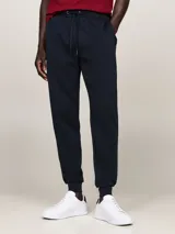 Pantalón de jogging azul marino, confeccionado en mezcla de algodón y poliéster, con cintura ajustable mediante cordón y puños elásticos en los tobillos. Presenta bolsillos laterales y un bolsillo trasero de ojal.